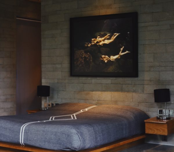 Image of bedroom with platform bed and large mural above bed